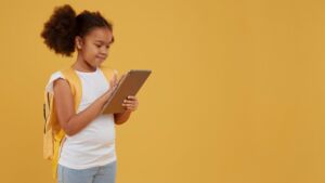 Menina usando o tablet com jogos digitais como recurso para melhorar o aprendizado