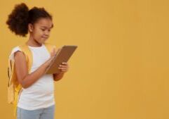 Menina usando o tablet com jogos digitais como recurso para melhorar o aprendizado